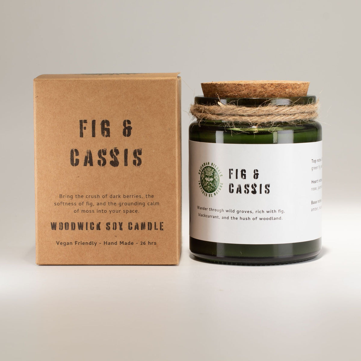 Fig and Cassis woodwick soy candle in a green glass jar beside its kraft gift box