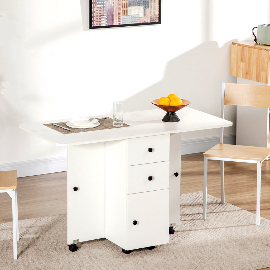 White drop‑leaf folding dining table with storage drawers.