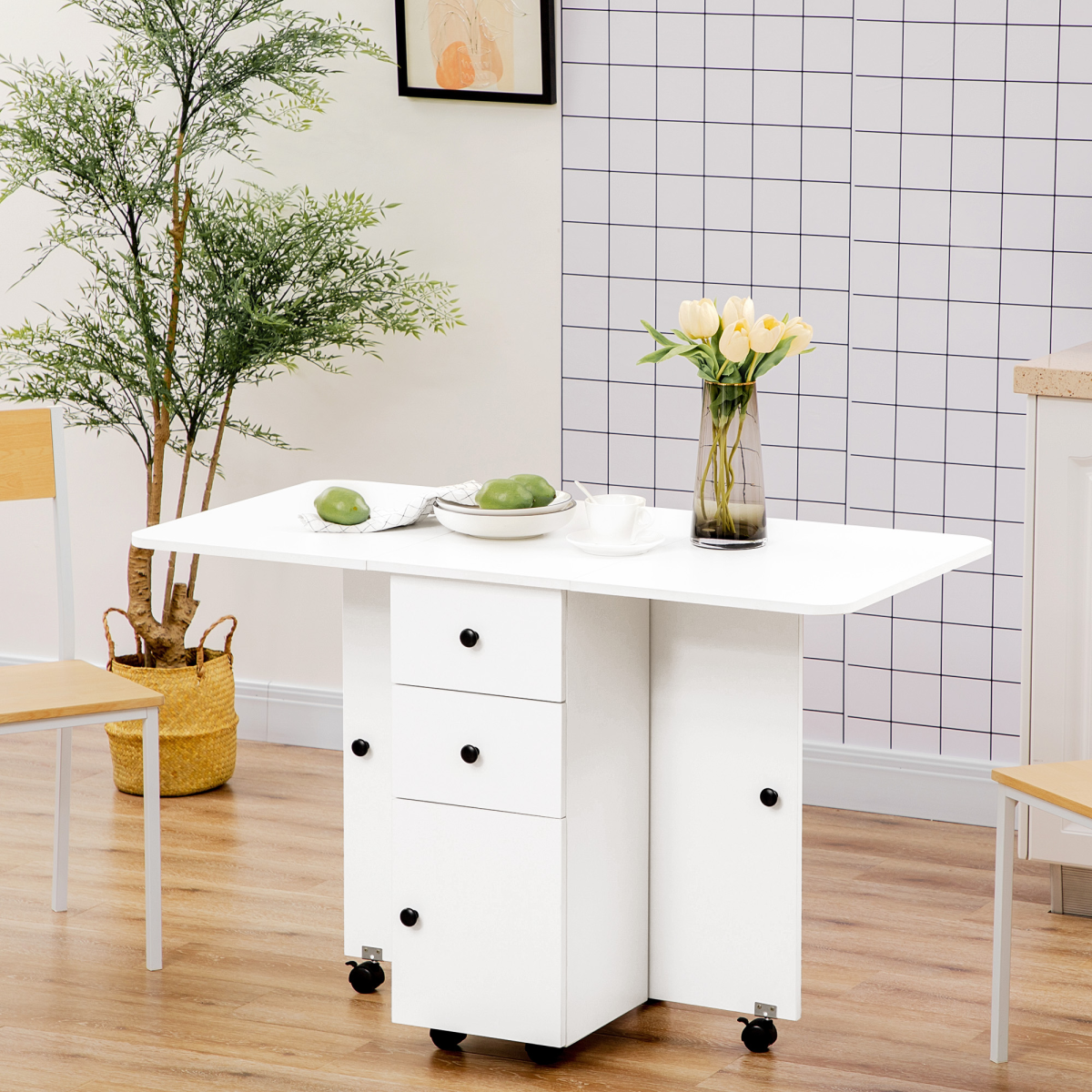 White drop‑leaf folding dining table with storage drawers.