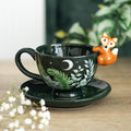 Green foliage ceramic teacup and saucer with a fox at the rim