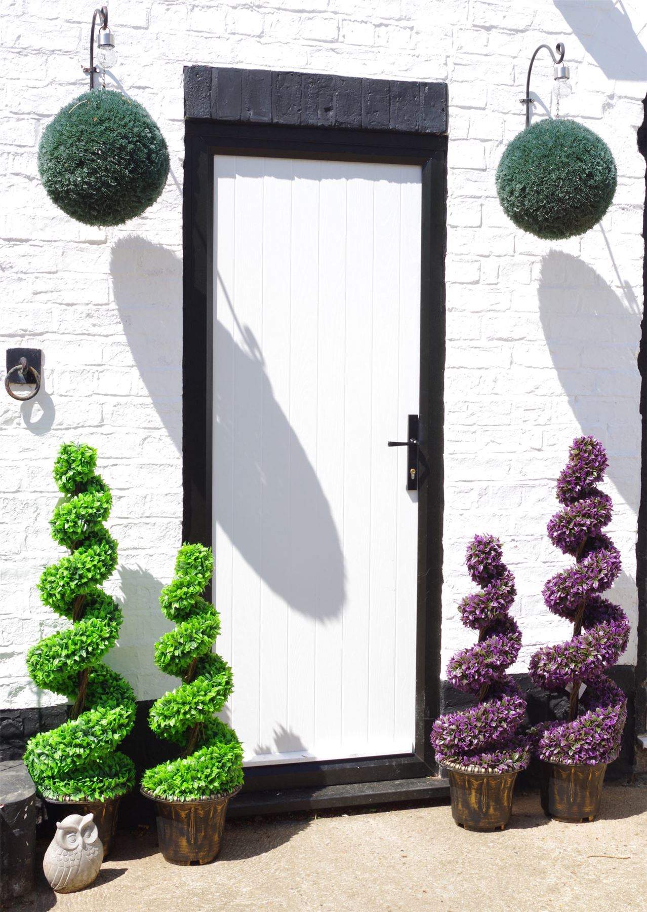 Pair of 120cm spiral topiary trees with decorative planters.
